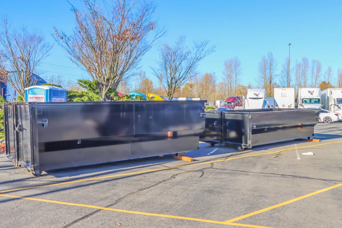 Professional dumpster rental service with roll-off container on residential driveway in Ojus